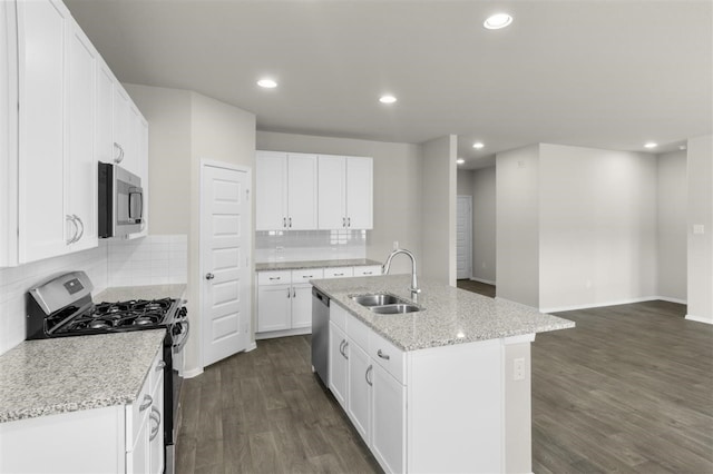 kitchen with stainless steel appliances, sink, white cabinets, an island with sink, and dark hardwood / wood-style floors