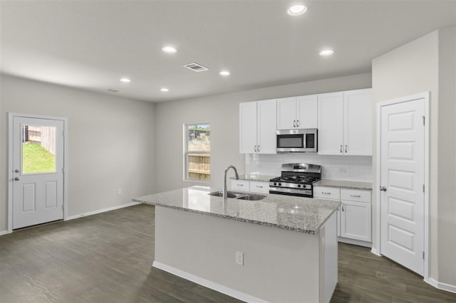 kitchen featuring appliances with stainless steel finishes, white cabinetry, a kitchen island with sink, and sink