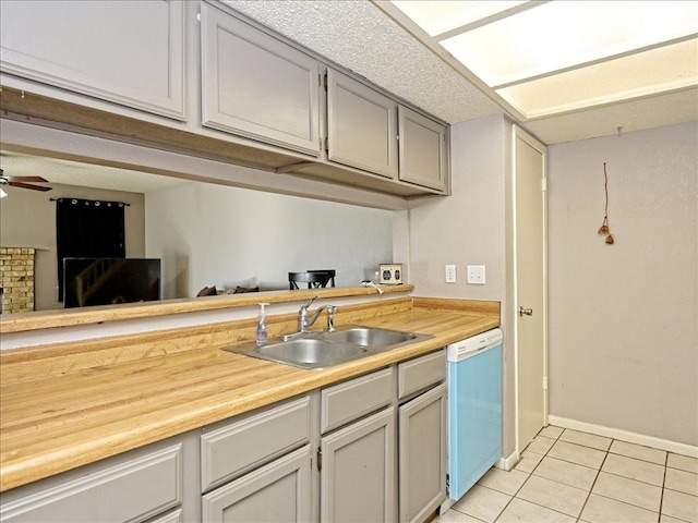 kitchen featuring white dishwasher, gray cabinets, sink, ceiling fan, and light tile floors