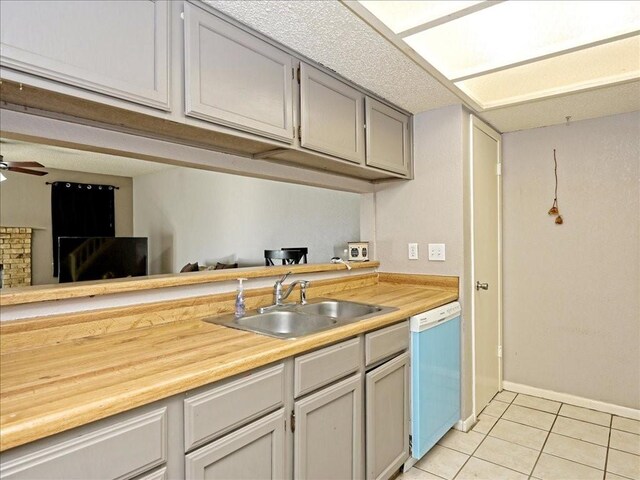 7825 Beauregard Cir Unit 5, Austin, TX 78745 - kitchen with dishwashing machine, light tile patterned floors, ceiling fan, a fireplace, and wood counters