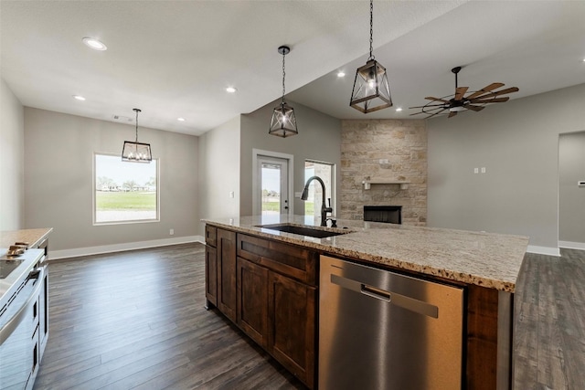 kitchen with sink, stainless steel dishwasher, dark hardwood / wood-style floors, white stove, and a fireplace