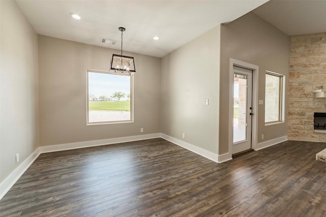 interior space with a stone fireplace, dark hardwood / wood-style flooring, and a wealth of natural light