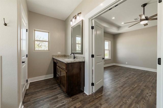 bathroom featuring ceiling fan, vanity, wood-type flooring, and a healthy amount of sunlight