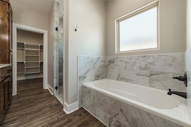 bathroom with vanity, hardwood / wood-style flooring, and plus walk in shower