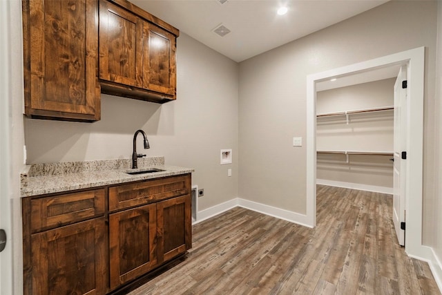 kitchen with light stone countertops, sink, and light hardwood / wood-style flooring