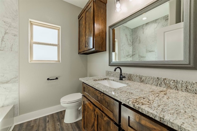 bathroom with a shower, hardwood / wood-style flooring, vanity, and toilet