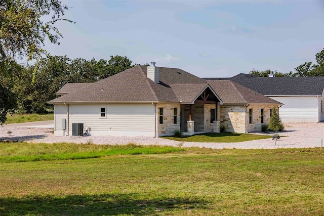 view of front of house with cooling unit and a front lawn