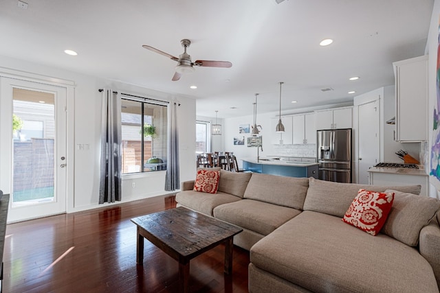 living room featuring dark hardwood / wood-style flooring and ceiling fan