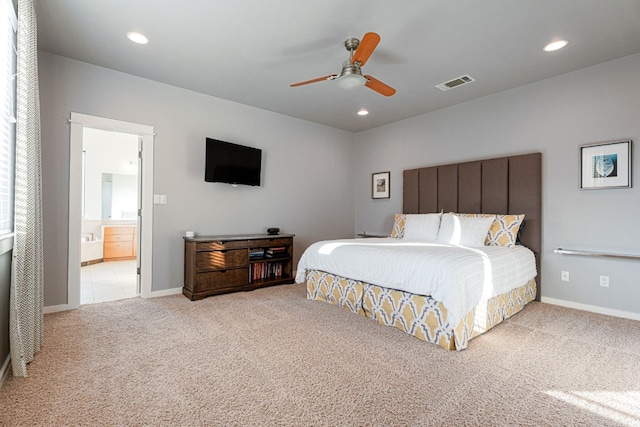 bedroom with ensuite bathroom, ceiling fan, and light colored carpet