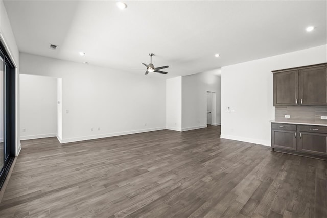 unfurnished living room with ceiling fan and dark wood-type flooring