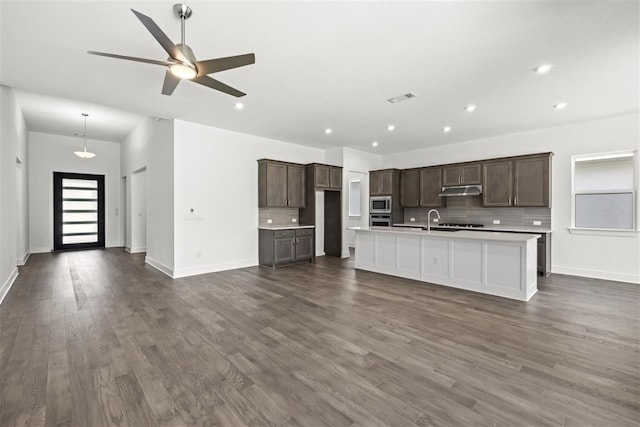 kitchen featuring visible vents, open floor plan, stainless steel appliances, light countertops, and under cabinet range hood