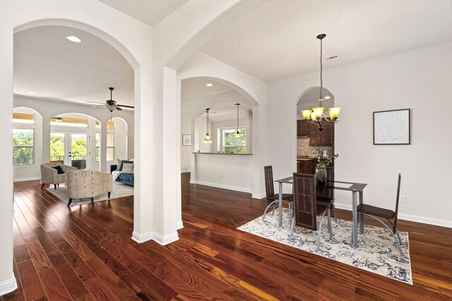 dining area featuring ceiling fan with notable chandelier, plenty of natural light, and dark hardwood / wood-style flooring