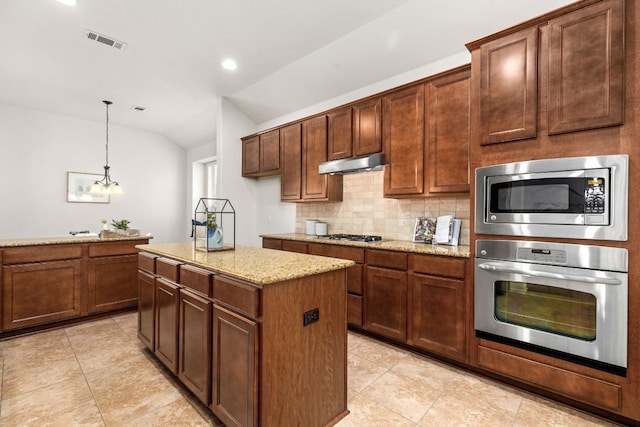 kitchen featuring a kitchen island, vaulted ceiling, light stone countertops, tasteful backsplash, and stainless steel appliances