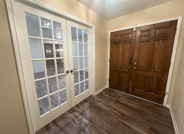 entryway with a textured ceiling, dark wood-type flooring, and french doors