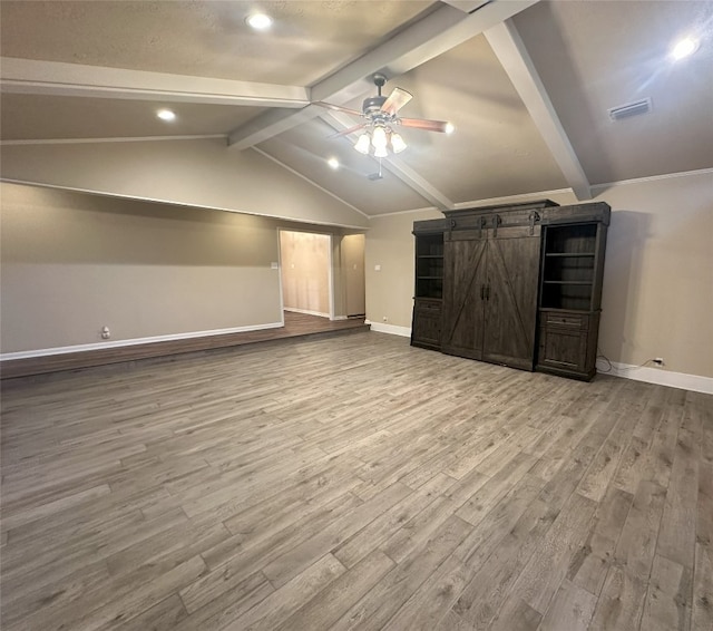 bonus room with a barn door, ceiling fan, vaulted ceiling with beams, and wood-type flooring