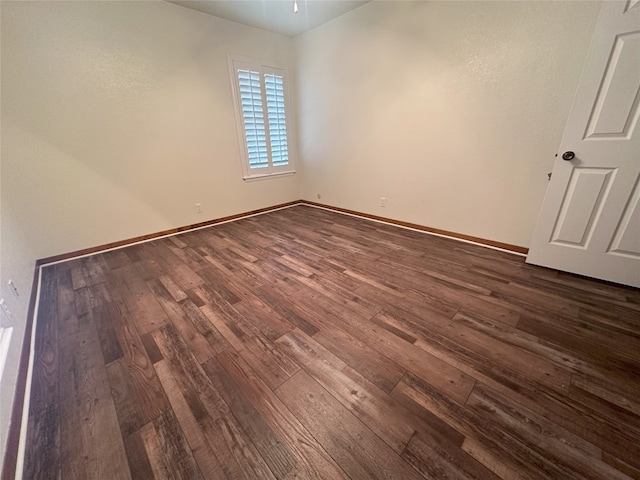 unfurnished room with dark wood-type flooring