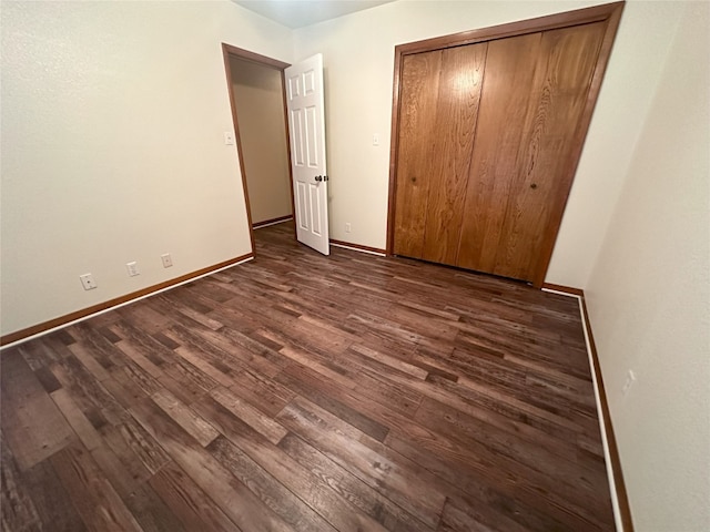 unfurnished bedroom featuring a closet and dark hardwood / wood-style flooring