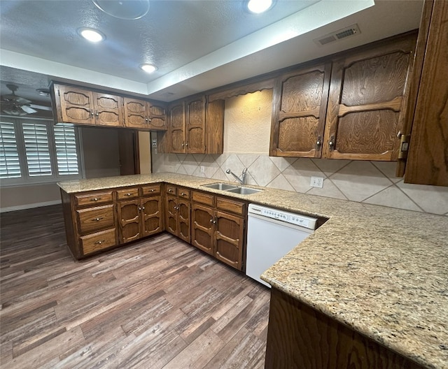 kitchen featuring ceiling fan, sink, white dishwasher, tasteful backsplash, and dark hardwood / wood-style flooring