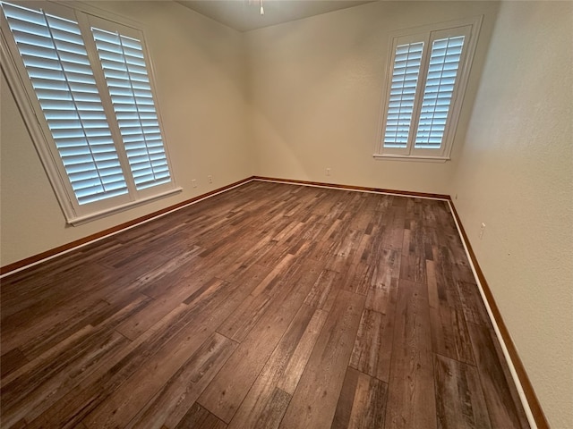 empty room with dark hardwood / wood-style flooring