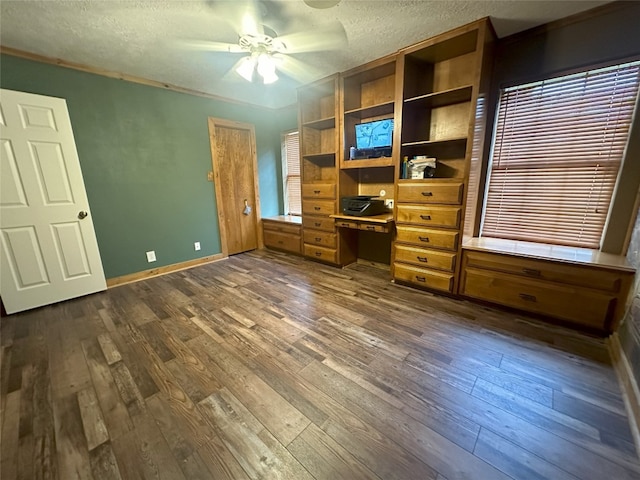 unfurnished office with a textured ceiling, ceiling fan, and dark hardwood / wood-style floors