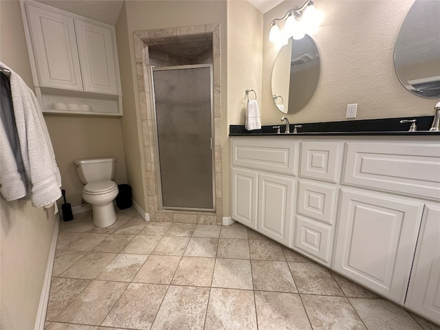 bathroom with tile floors, a shower with shower door, toilet, and dual bowl vanity