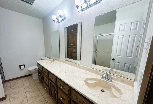 bathroom featuring toilet, a textured ceiling, double sink vanity, and tile flooring