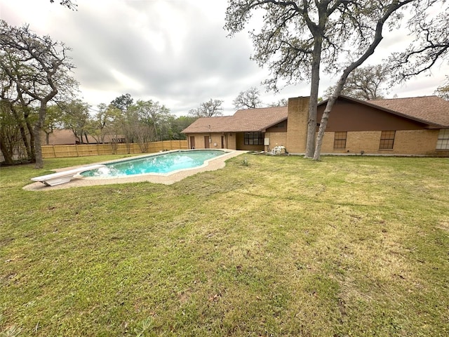 view of swimming pool featuring a diving board and a lawn