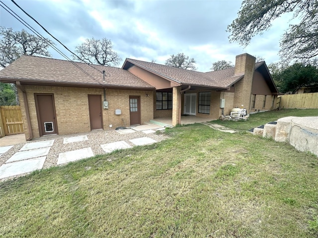 back of house with a patio area and a lawn