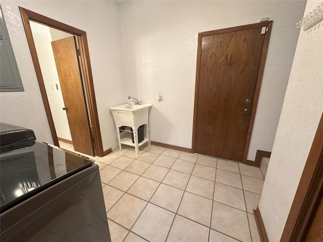 interior space featuring washer / clothes dryer, sink, and light tile floors