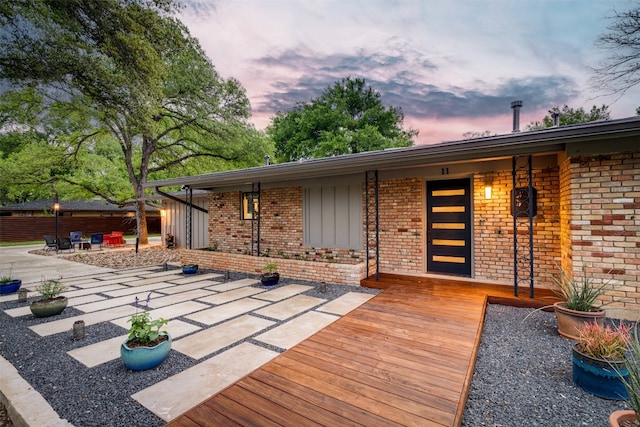 deck at dusk featuring a patio area