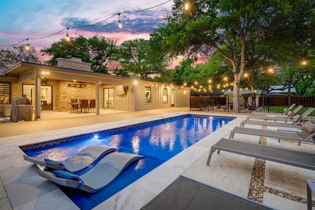 pool at dusk with a patio