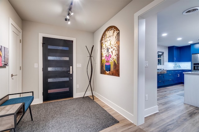 foyer entrance featuring rail lighting and light hardwood / wood-style floors