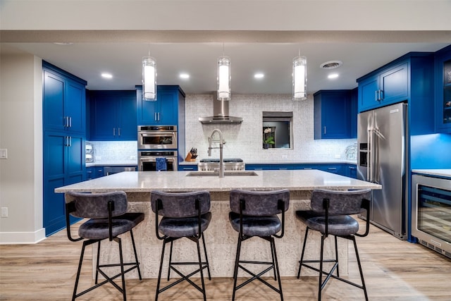 kitchen with tasteful backsplash, stainless steel appliances, a kitchen island with sink, and a breakfast bar