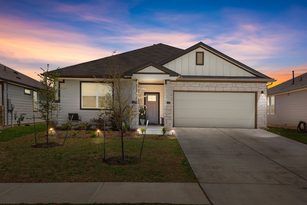 view of front of home with a yard and a garage