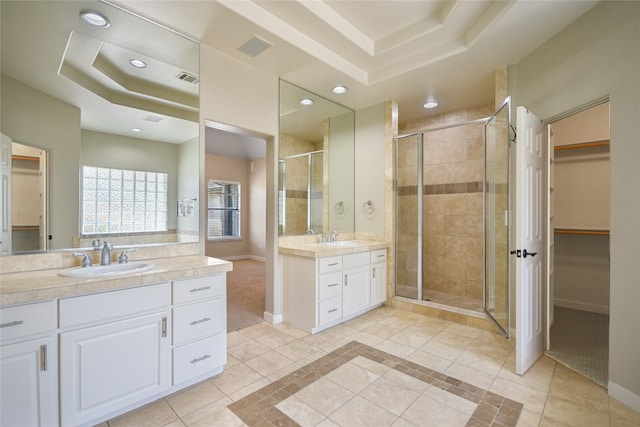 bathroom with vanity, a raised ceiling, tile patterned flooring, and a shower with door