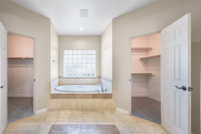 bathroom featuring tiled tub and tile patterned floors