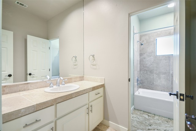 bathroom with tiled shower / bath and vanity