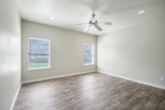 empty room with ceiling fan, wood-type flooring, and plenty of natural light