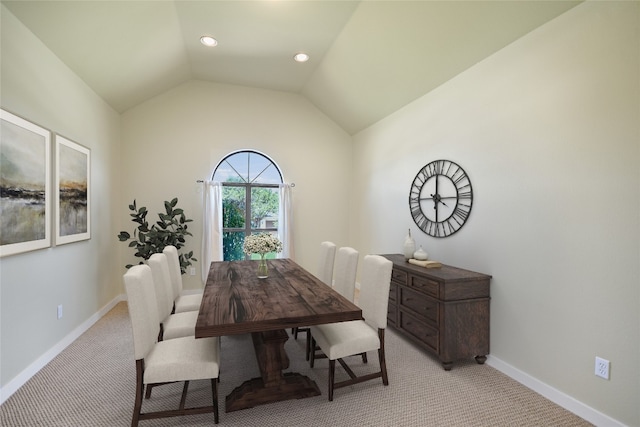 dining space featuring lofted ceiling and light colored carpet