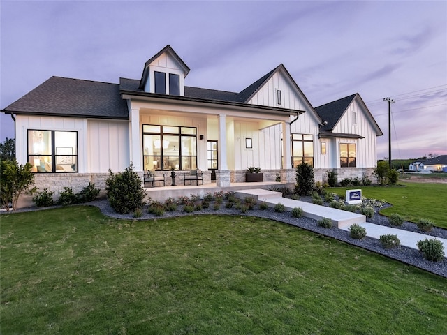 modern inspired farmhouse with covered porch and a yard