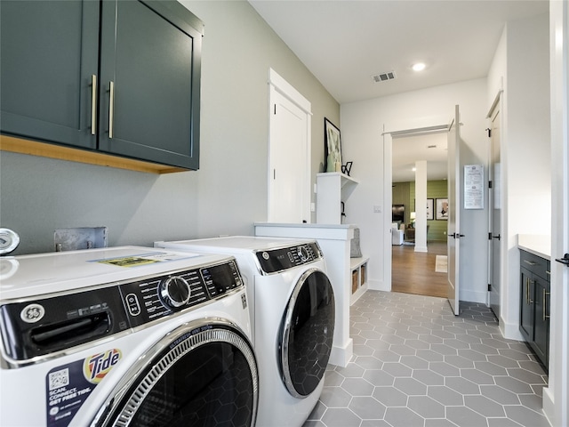 laundry room featuring cabinets, separate washer and dryer, and tile flooring