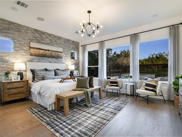 bedroom featuring an inviting chandelier, dark hardwood / wood-style floors, and multiple windows