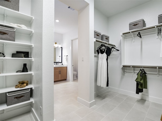 walk in closet featuring light tile floors