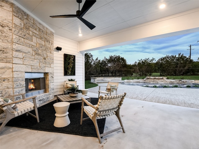 view of patio / terrace featuring an outdoor stone fireplace, a swimming pool, and ceiling fan