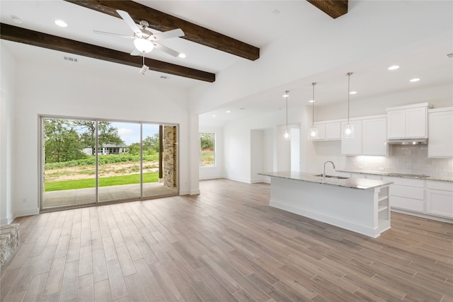 kitchen with light hardwood / wood-style floors, sink, beam ceiling, and white cabinets