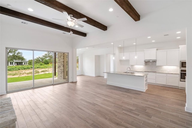 unfurnished living room with light wood-style floors, recessed lighting, and a sink