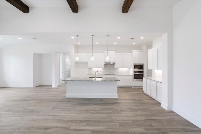 kitchen with white cabinets, appliances with stainless steel finishes, light wood-type flooring, under cabinet range hood, and a sink