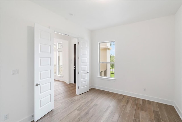 unfurnished room with light wood-style floors and baseboards