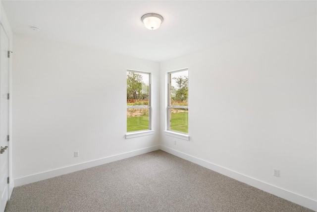 carpeted empty room with baseboards