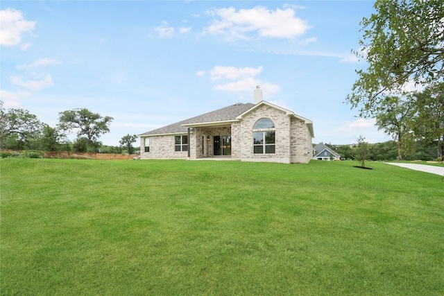 back of property featuring a yard and a chimney